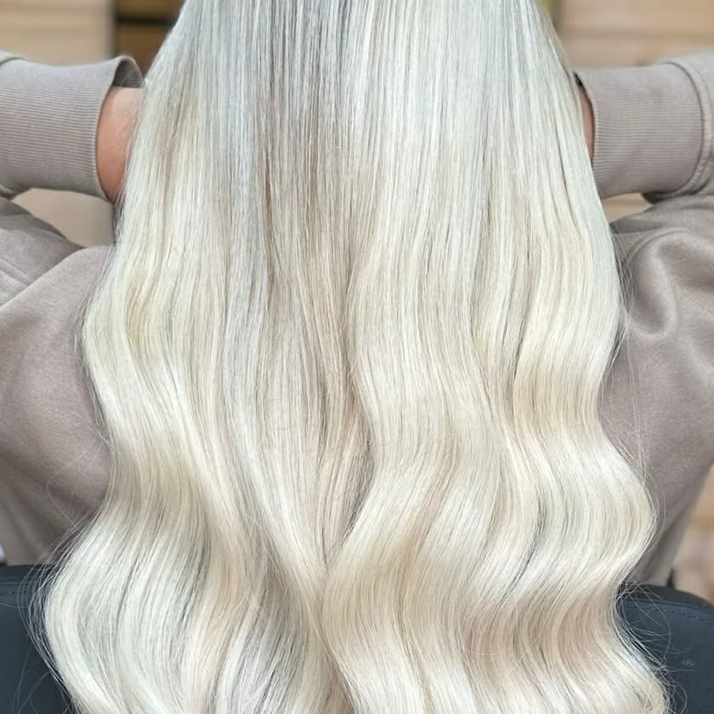 Icy blonde salon result with soft waves and a natural shadow root